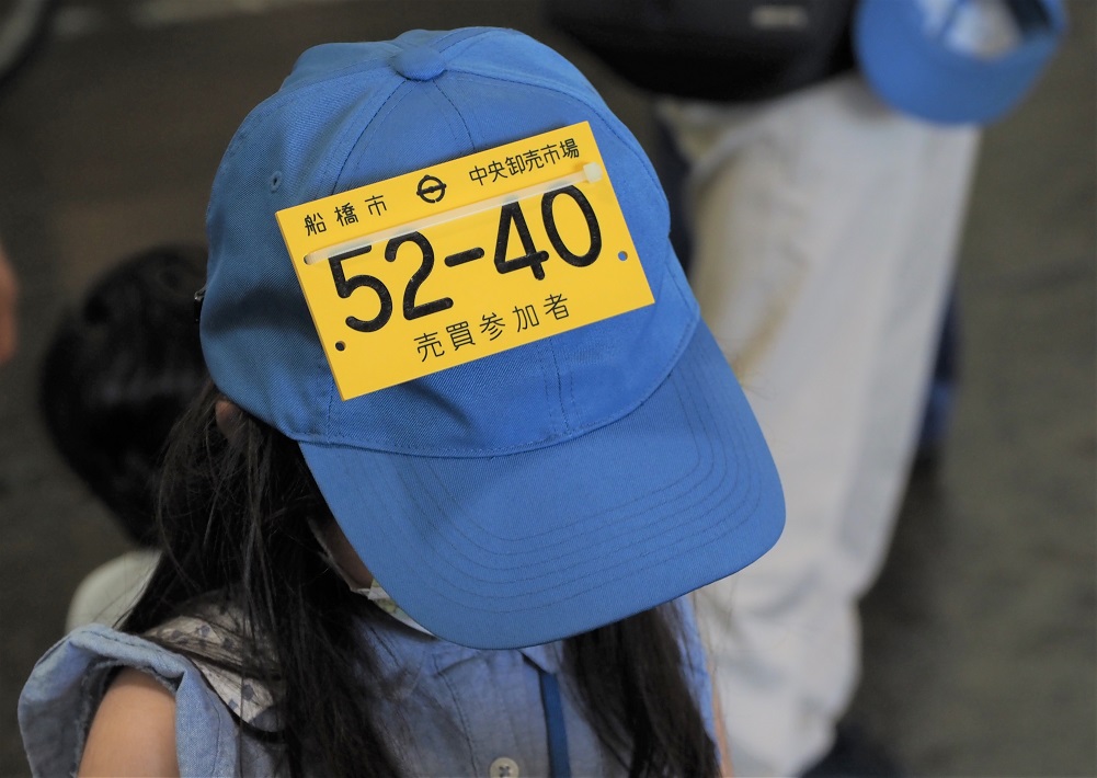 「売買参加者」のプレート付きの帽子