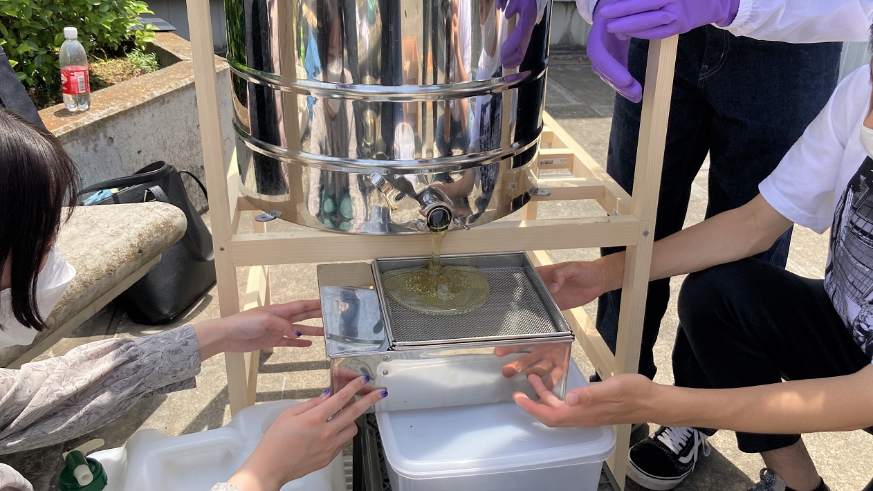 手動の遠心分離機で蜜を木枠から落とす