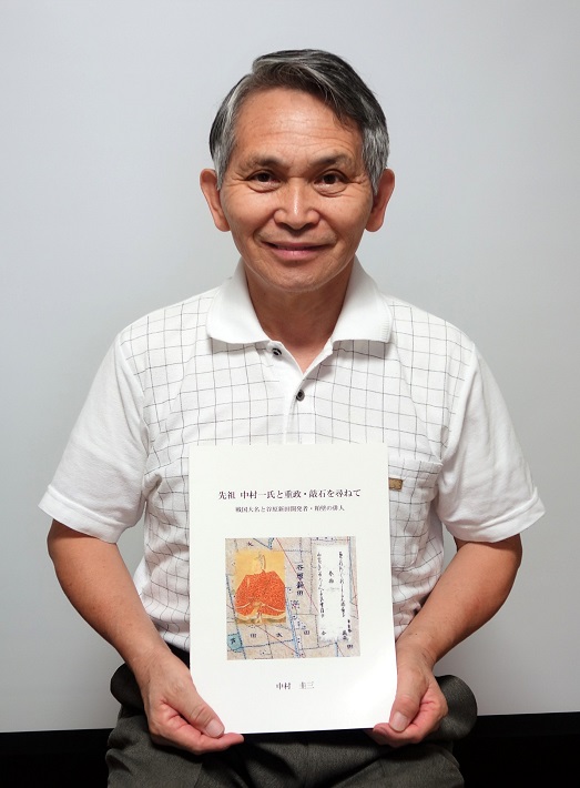 記録集『先祖 中村一氏と重政・敲石を尋ねて』を手にする中村圭三さん