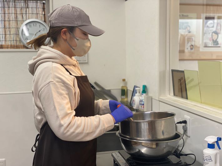 創業時に掲げた経営理念が常に目に入る場所にある工房で作業をする美咲さん