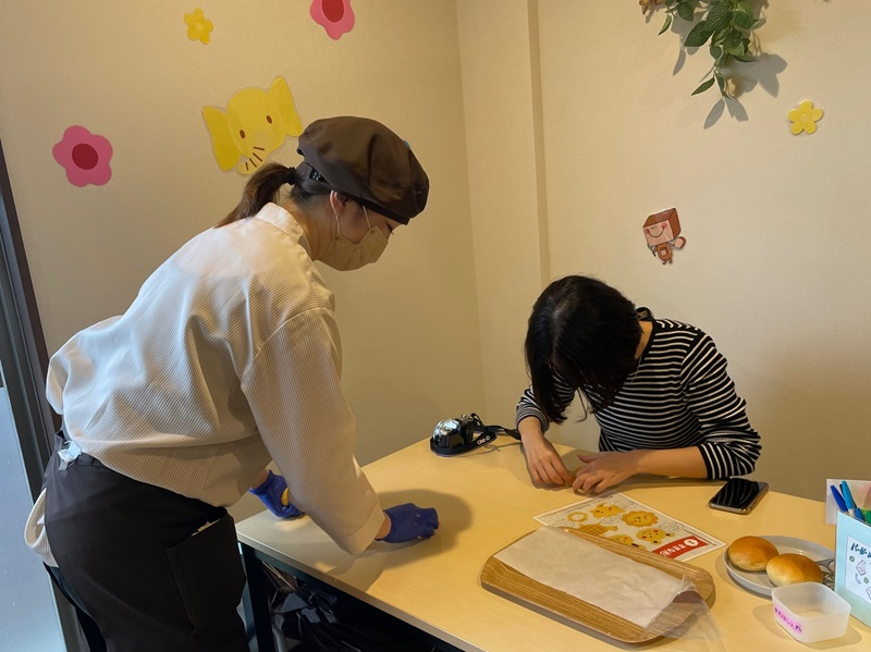 パン作り体験をする女性と先生