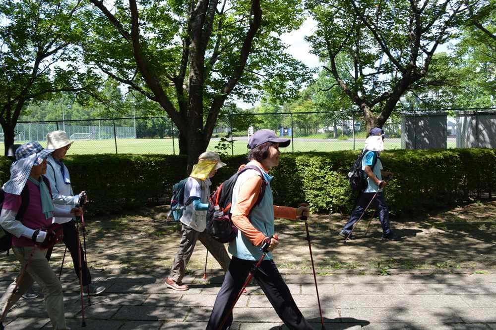 ポールを使った歩き方のお手本。視線は前、歩幅は広く、胸を張って
