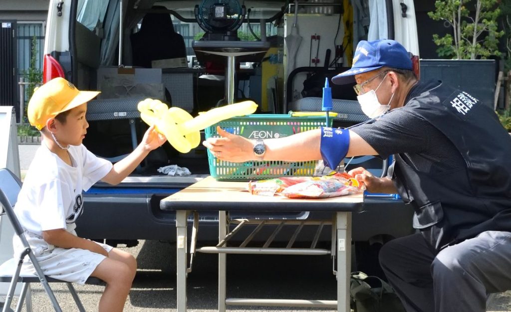移動交番相談員稲川さんと青木さん 風船アートをプレゼント