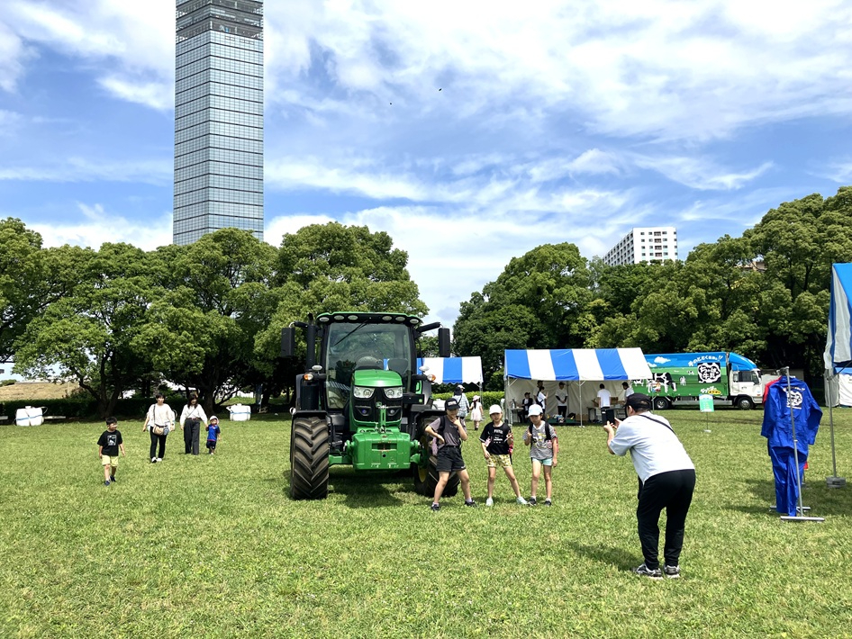 ポートタワーをバックに巨大トラクターと写真撮影（2024年）