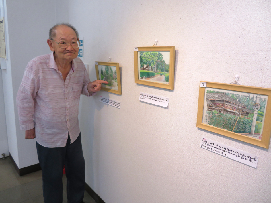 展覧会で作品を見る福田芳生さん