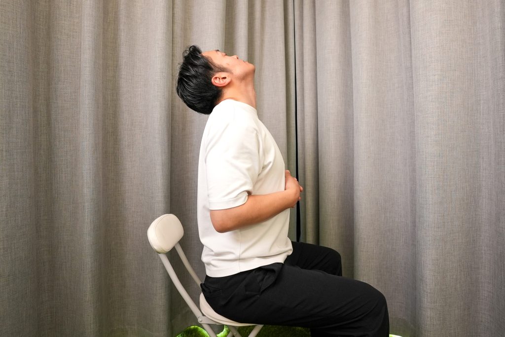 手を胸の下に引き付けて、鼻から息を吸いながら、肩を落として肩を後ろにし、顎を上げて首を伸ばす