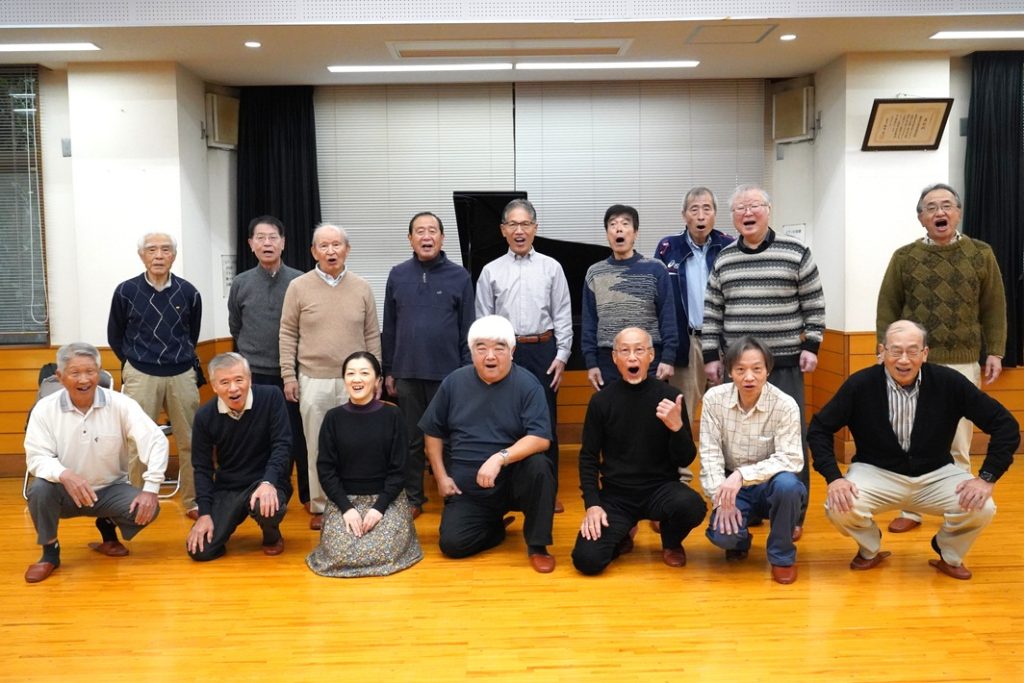 野田男声合唱団。前列中央が指揮者の齋藤令さん、隣の女性がピアノの名倉扶季さん、後列右端が団長の田中さん