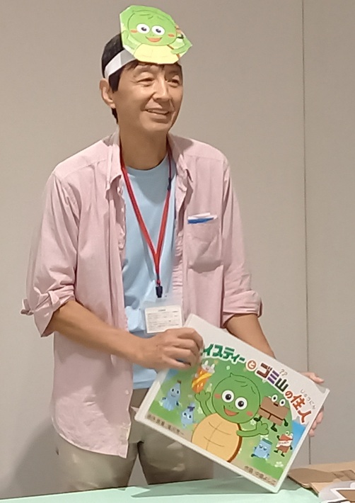 子ども向けの「体験型ごみ分別紙芝居」を手にする佐藤さん