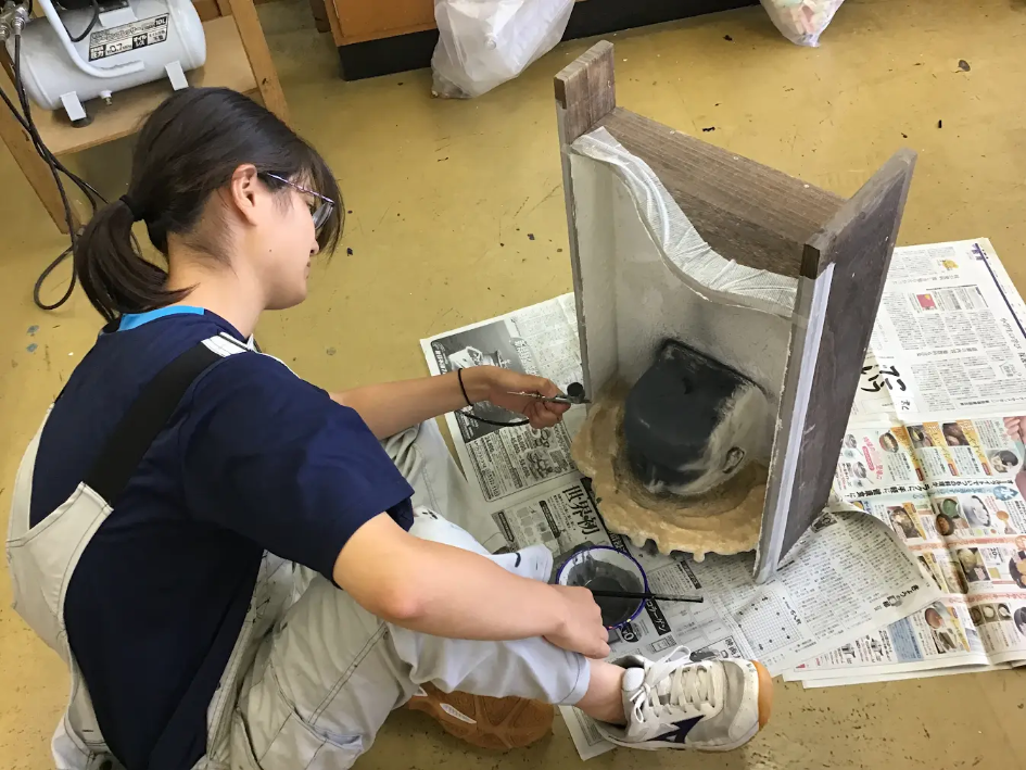 作品の頭部にブラッシングする宮澤さん