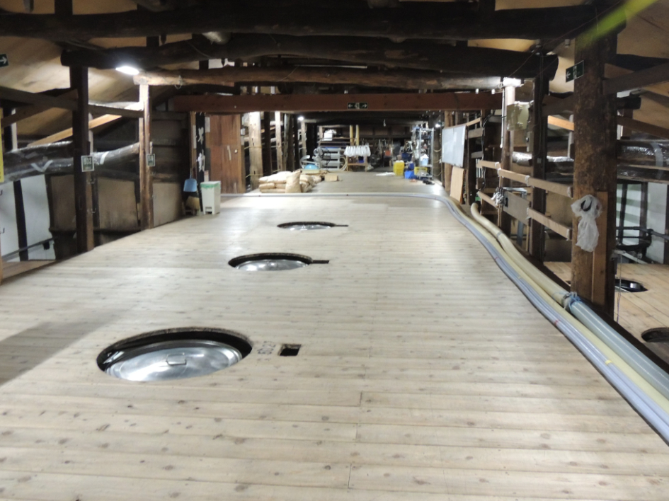 鍋店の酒蔵。もろみが入ったタンクが並ぶ