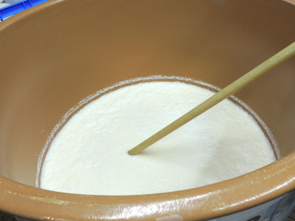 蒸米、麹、仕込水が 入った酒母（しゅぼ）を櫂棒でかき混ぜる