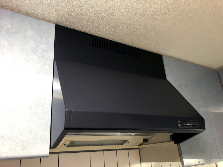 従来のブーツ型カバーに覆われた換気扇。フィルターで油をキャッチしてダクトを通じて排気するタイプ
