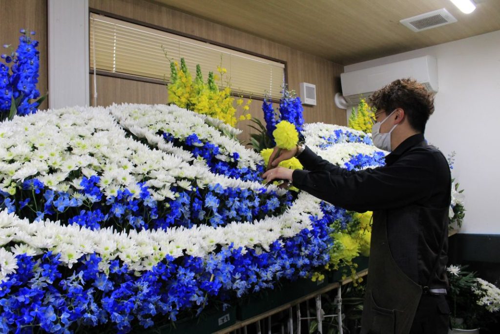 ディア・ダイヤモンド株式会社　作業中の社員。葬儀の顔となる花祭壇は式の印象をも左右する